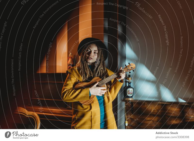 Stilvolle junge Frau spielt Gitarre spielen Hipster Musik stylisch ernst tausendjährig Ukulele hawaiianisch stehen fokussiert konzentriert praktizieren Musiker