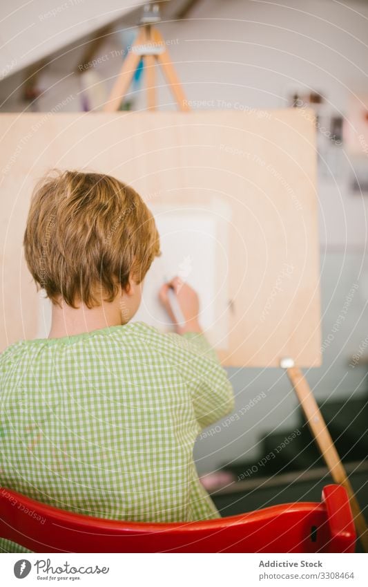 Kind zeichnet zu Hause auf Leinwand zeichnen Bild Junge Kunst ernst Windstille Farbe Hobby heimwärts friedlich lässig Kindheit Appartement flach kreativ