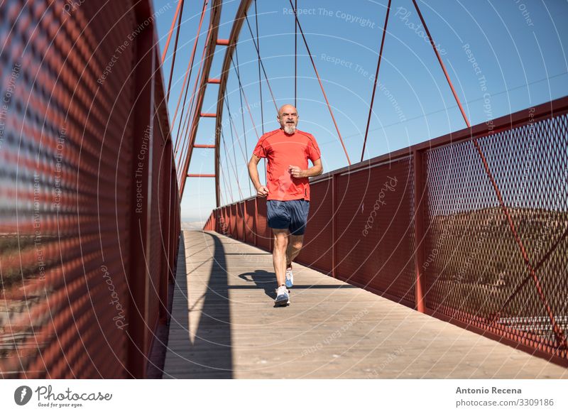 Seniorenlauftraining auf einer Brücke Lifestyle Sport Mensch Mann Erwachsene Glatze Vollbart alt Fitness rot weiß Gelassenheit anstrengen laufen Läufer reif 60s