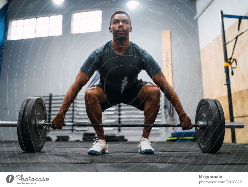 Crossfit-Sportler, der mit einer Langhantel trainiert. Lifestyle Körper Mann Erwachsene Fitness sportlich muskulös stark schwarz Kraft Konzentration Curl-Hantel