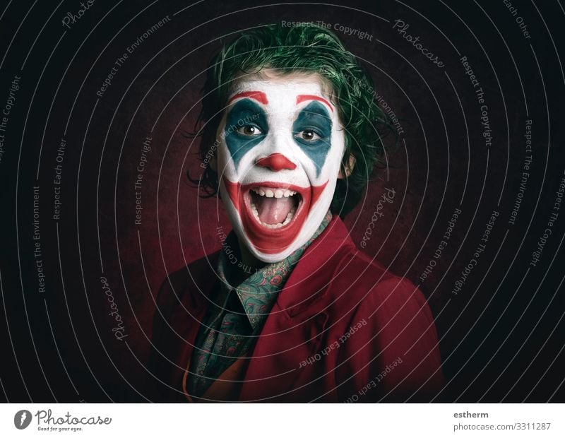 lächelnder Junge als Joker verkleidet auf dunklem Hintergrund Lifestyle Freude Schminke Spielen Entertainment Party Veranstaltung Feste & Feiern Karneval