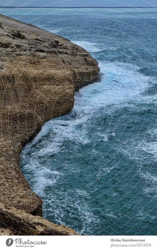 Schroffe Klippe im Mittelmeer Meer Wellen Wasser Brandung Felsen Sardinien Küste steil Stein düster Abend schroff Natur Landschaft Horizont blau