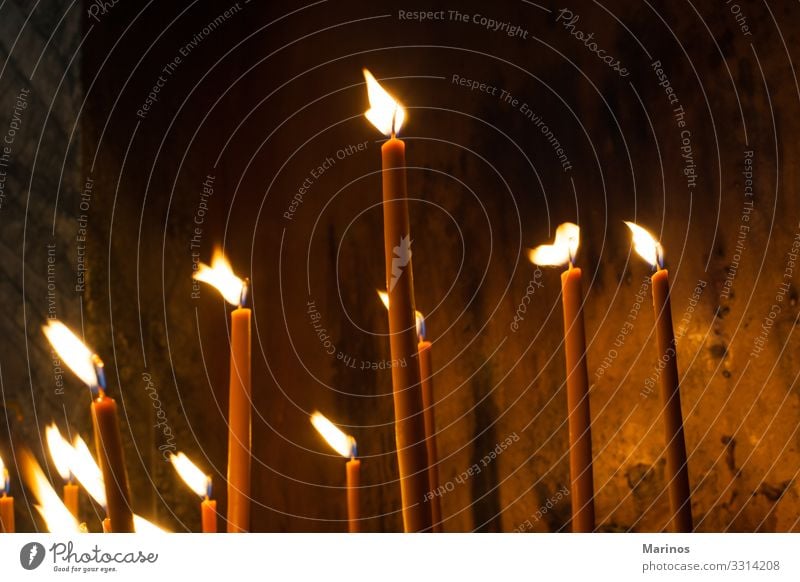 Kerzen in einer orthodoxen Kirche anzünden. Lifestyle Ostern Weihnachten & Advent Feuer leuchten Hoffnung Religion Licht Innenaufnahme