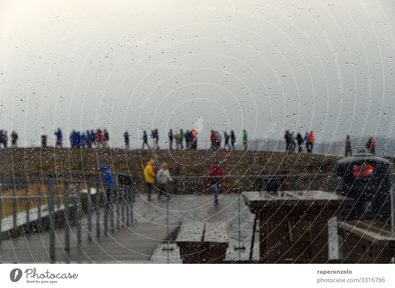 Touristen in kleinen Gruppen an einer Sehenswürdigkeit, fotografiert durch eine regennasse Scheibe Regen Regentropfen Fensterscheibe Regentag verregnet