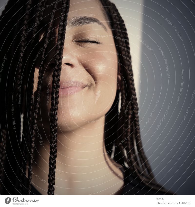 zufriedene Frau mit geflochtenen Haaren in der Abendsonne Raum feminin Erwachsene 1 Mensch Mauer Wand T-Shirt brünett langhaarig Afro-Look genießen Lächeln