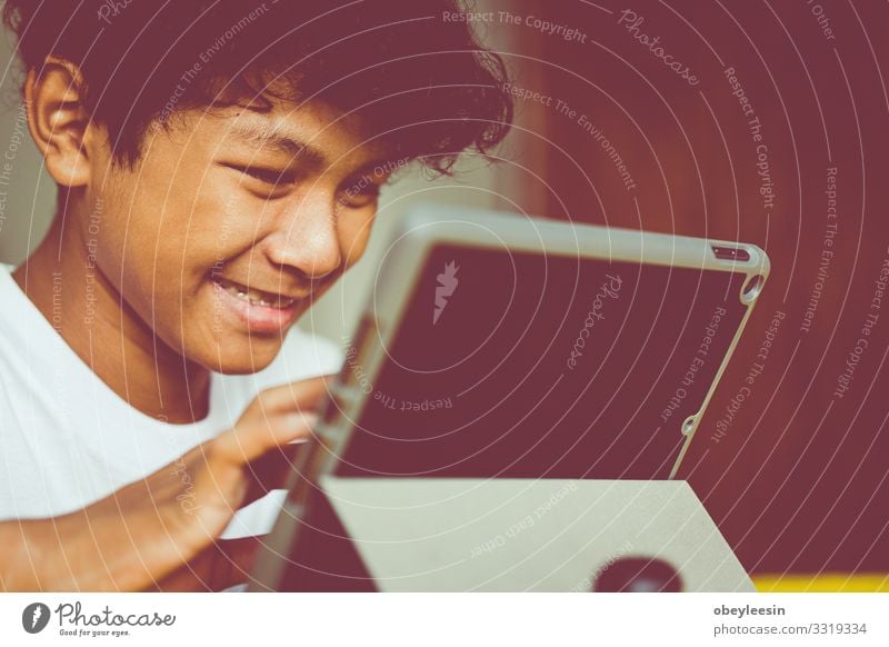 asiatischer Junge hat eine gute Zeit mit seiner Tablette Freude Glück Spielen lesen Sommer Garten Schlafzimmer Kind Computer Technik & Technologie Internet
