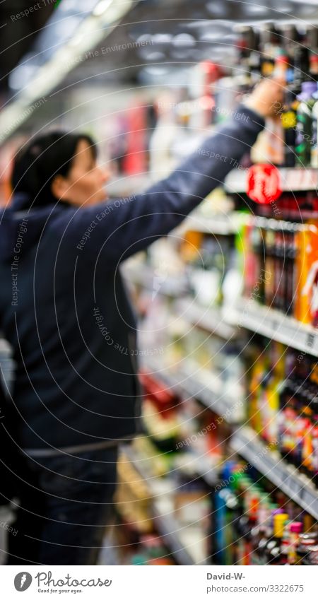 Frau schaut sich die Ware in einem Supermarktregal an Einkaufswagen Lebensmittel einkaufen Farbfoto Konsum Ladengeschäft Mensch verbraucher hand legen