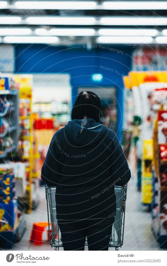 Frau geht mit dem Einkaufswagen durch das Geschäft Lebensmittel einkaufen Supermarkt Farbfoto Konsum Ladengeschäft Mensch verbraucher hand legen Verbraucher