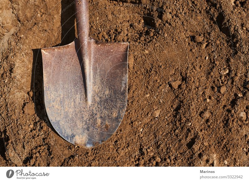 Schaufel auf dem Boden im Hintergrund.Gartenarbeit. Arbeit & Erwerbstätigkeit Werkzeug Natur Erde Sand Metall braun schaufeln Graben Ackerbau Golfloch Frühling