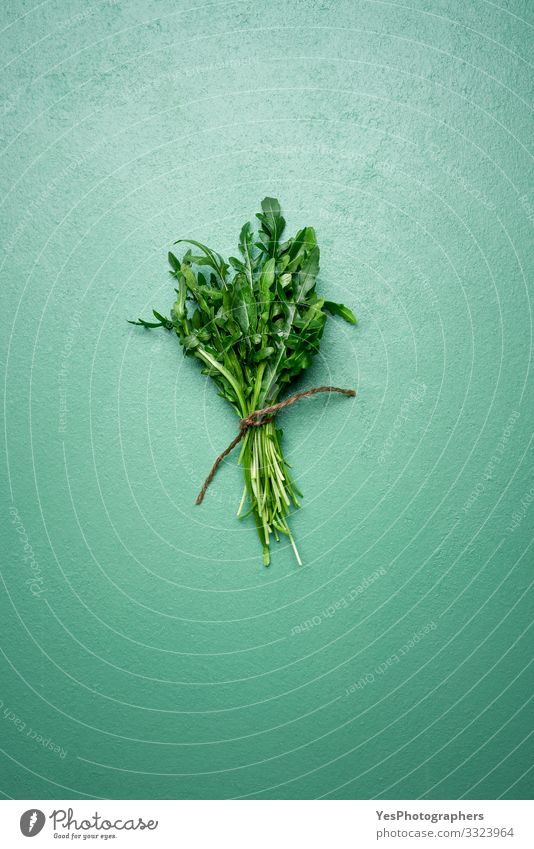 Frische Rucola-Blätter in einem Strauß auf grünem Tisch. Rucola-Bündel Gemüse Salat Salatbeilage Bioprodukte Vegetarische Ernährung Diät Gesunde Ernährung