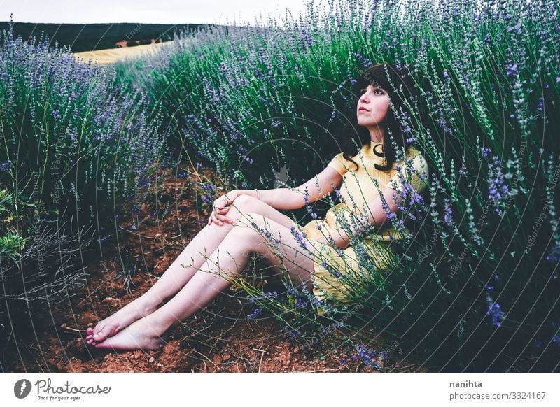 Junge brünette Frau sitzt umgeben von Lavendel jung hübsch retro altehrwürdig Natur natürlich wirklich offen sich[Akk] entspannen Ruhe Szene Blumen Frühling