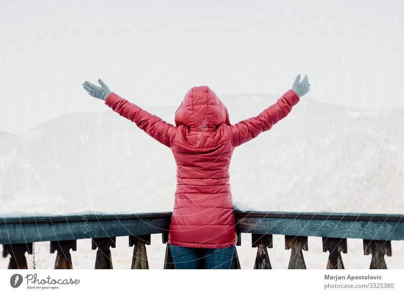 Frau steht mit erhobenen Händen mit Blick auf die Berge Lifestyle Ferien & Urlaub & Reisen Tourismus Ausflug Abenteuer Freiheit Winter Winterurlaub