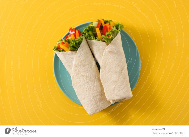 Pflanzliche Tortilla-Wraps isoliert auf gelbem Hintergrund. Ansicht von oben Gemüse umhüllen Brötchen Fladenbrot Lebensmittel Gesunde Ernährung Foodfotografie