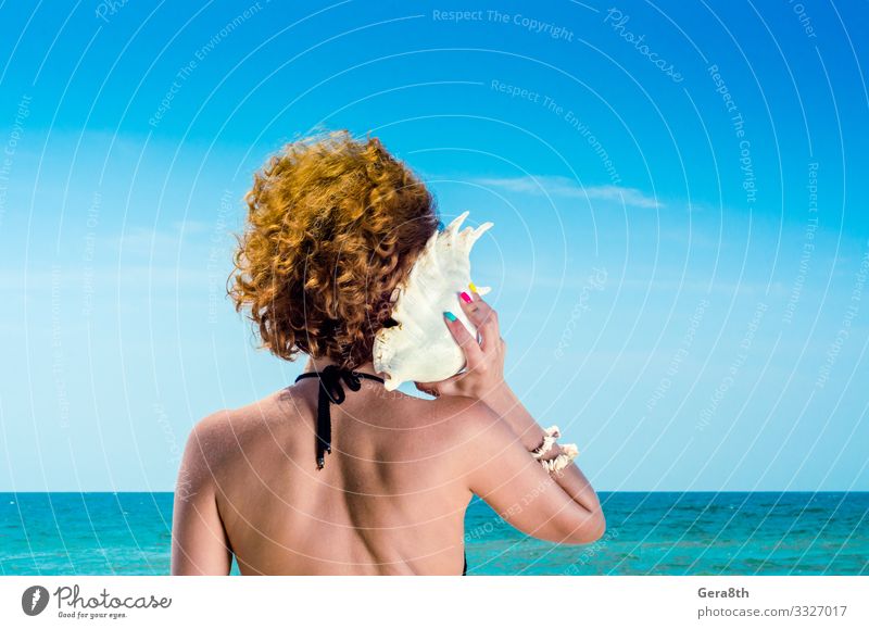 junge Frau mit roten Haaren mit einer großen Muschel Maniküre Ferien & Urlaub & Reisen Sommer Strand Meer Junge Frau Jugendliche Erwachsene Finger Natur Wolken