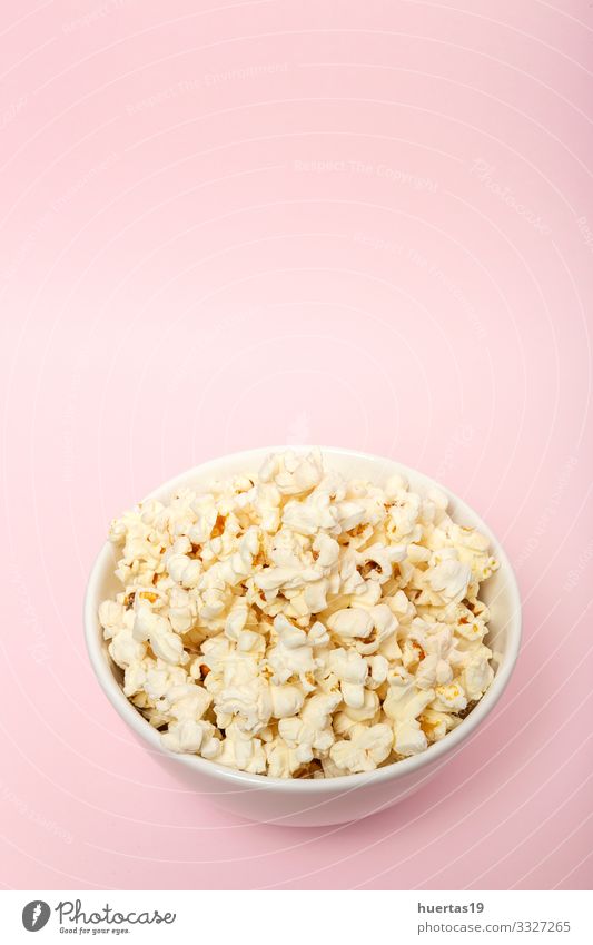 Popcorn auf farbigen Hintergründen Lebensmittel Picknick Fastfood Schalen & Schüsseln Entertainment Kino frisch lecker rosa weiß Farbe Popkorn Snack Mais salzig
