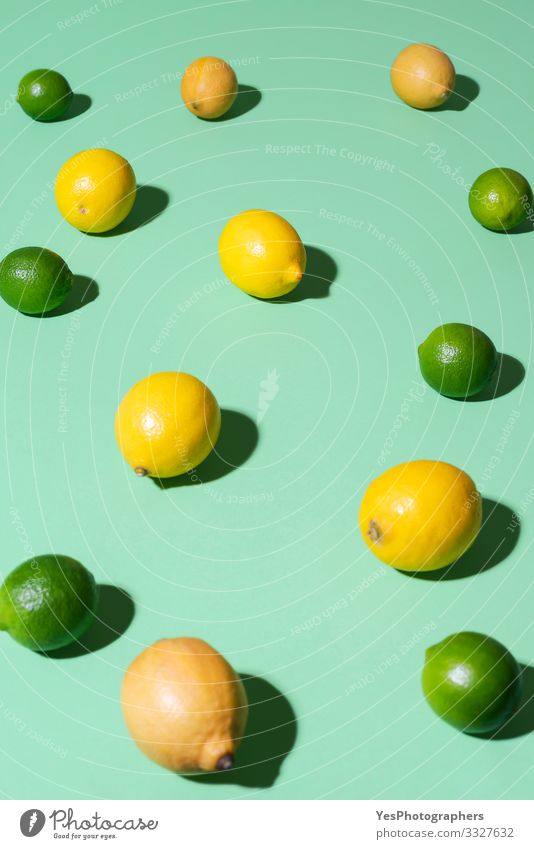 Zitronen- und Limettenfrüchte auf grünem Hintergrund. Sommerfrüchte Lebensmittel Frucht Frühstück Schönes Wetter frisch Aquaminthe heiter Zitrusfrüchte