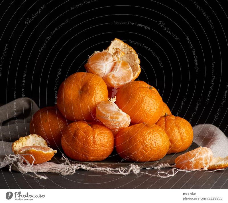 ungeschälte runde reife orangefarbene Mandarine Frucht Dessert Ernährung Vegetarische Ernährung Saft Teller Tisch Holz dunkel frisch natürlich saftig gelb grau