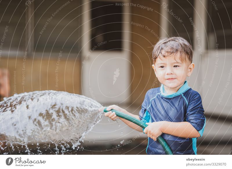 süßer Junge, der draußen mit Wasser in der Natur spielt Freude Glück Erholung Freizeit & Hobby Spielen Sommer Kind Schule lernen Mensch Kindheit Park Wiese