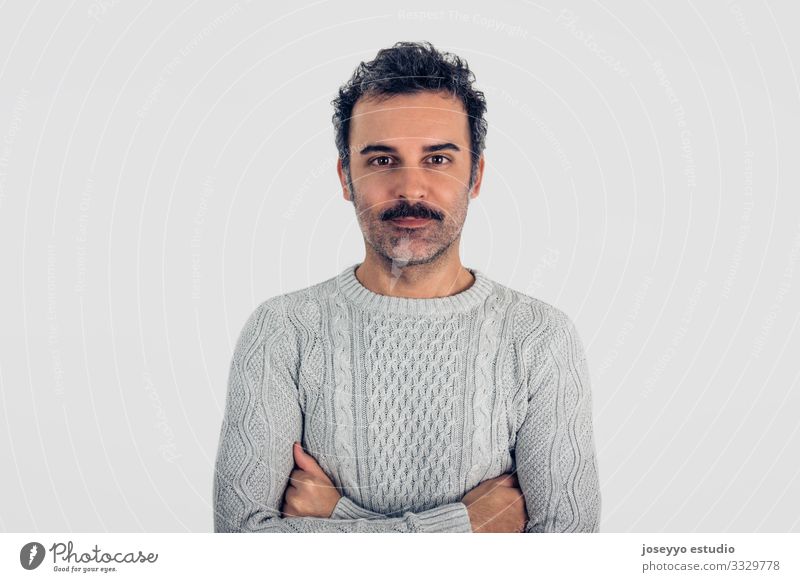 Mann mit Schnurrbart und grauem Pullover, stehend mit verschränkten Armen. Erwachsene attraktiv braun Krebs Freizeitbekleidung Kaukasier selbstbewußt Coolness