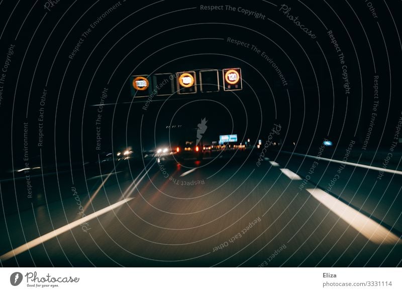 Autobahn mit Autos  und Schildern zur Geschwindigkeitsbegrenzung bei Nacht im dunkeln Verkehr Verkehrsmittel Personenverkehr Straßenverkehr Autofahren PKW