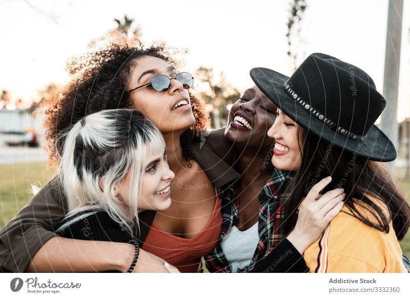 Multiethnische Gruppe von weiblichen Hipsterinnen, die mit jeder einzelnen kuscheln Menschengruppe Frau Kuscheln jung Stil Lächeln Umarmung Porträt Zusammensein