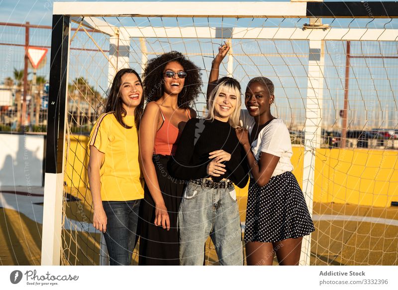 Fokussierte junge multirassische Freundinnen verbringen ihre Freizeit gemeinsam im Stadion aufwenden Frau Zusammensein Fußballtor Schüler genießen Zeitvertreib