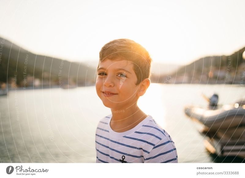 Süßes Kind lächelt bei Sonnenuntergang mit dem Meer im Hintergrund Lifestyle Freude Glück schön Gesicht Ferien & Urlaub & Reisen Tourismus Freiheit Sommer