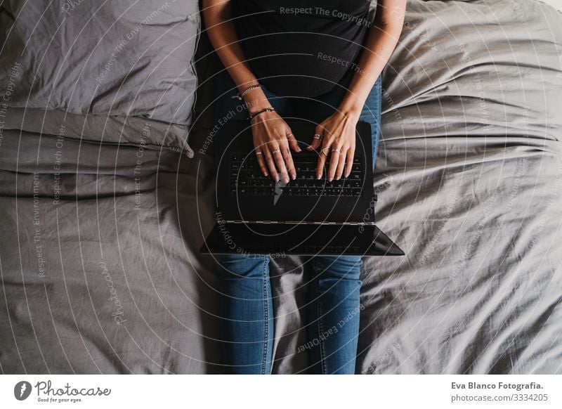 junge schwangere Frau, die zu Hause am Laptop arbeitet Notebook Computer Technik & Technologie benutzend heimwärts Bett erwartend Baby bauchfrei Internet WiFi