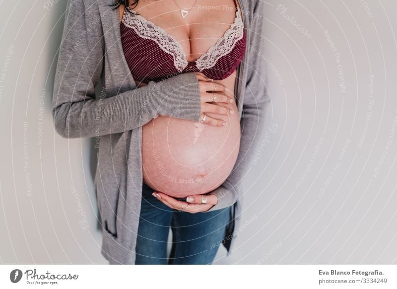 Porträt einer jungen schwangeren Frau zu Hause heimwärts Lifestyle erwartend Fenster Tag Leben Erwartung Beautyfotografie Kindererziehung mütterlich