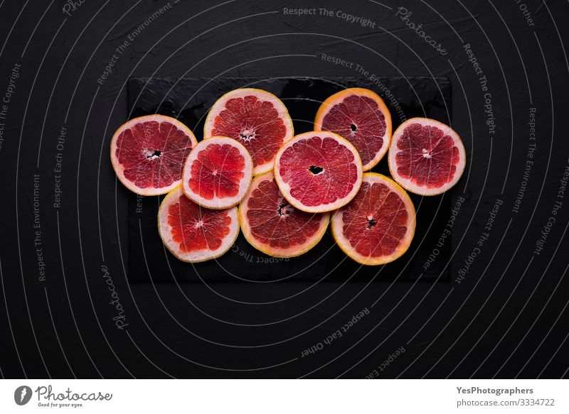 Grapefruitscheiben auf einem schwarzen Tisch. Geschnittene frische Zitrusfrüchte Lebensmittel Frucht Frühstück Gesunde Ernährung Gesundheit obere Ansicht