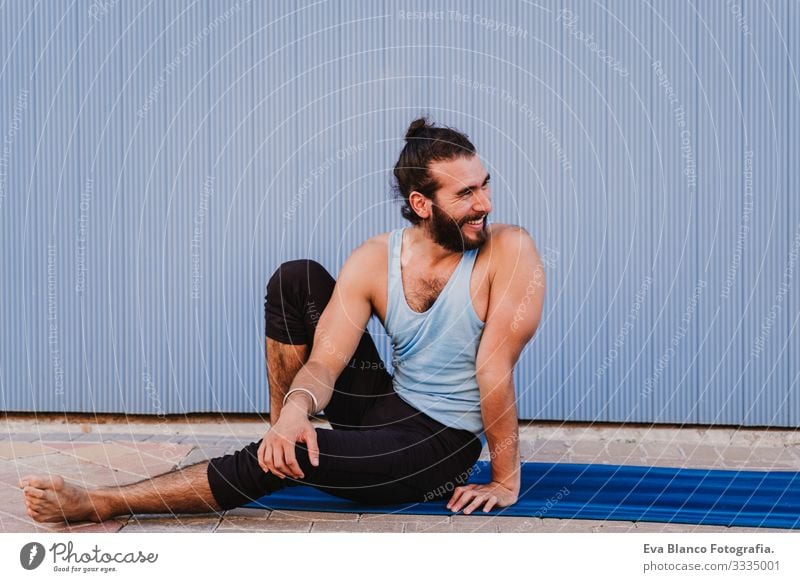 mann in der stadt, der yoga-sport betreibt und lächelt. blauer hintergrund. gesunde lebensweise Yoga Mann Sport Gesundheit Außenaufnahme Großstadt