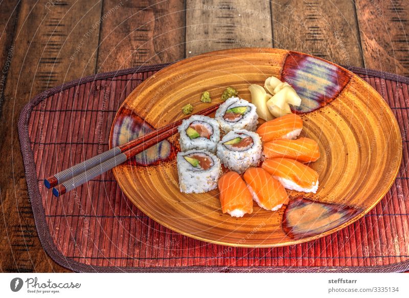 Lachs-Sushi-Rollen und Sake mit Wasabi Lebensmittel Fisch Mittagessen Teller Gesunde Ernährung orange Reiswein roher Fisch Mahlzeit Rohkost Essstäbchen Ingwer