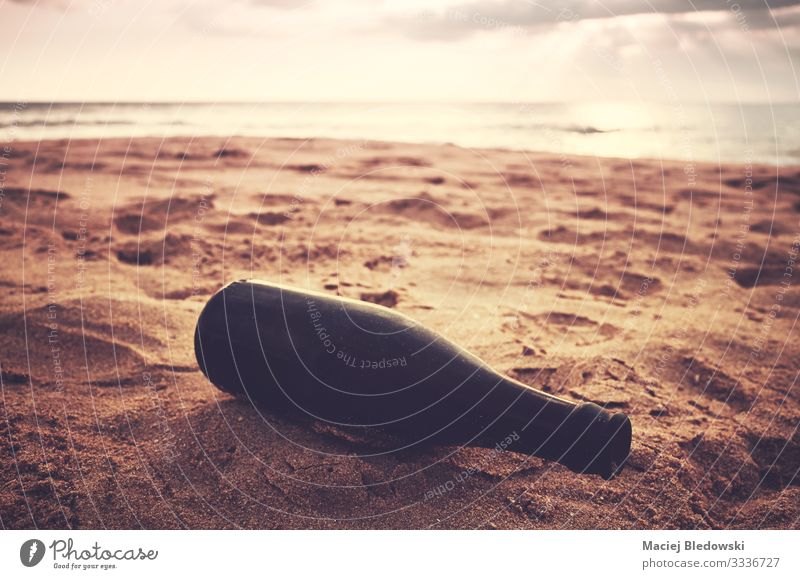 Leere Glasflasche an einem Strand bei Sonnenuntergang. Flasche Lifestyle Ferien & Urlaub & Reisen Sommer Sommerurlaub Meer Insel Natur Sand Himmel Küste retro