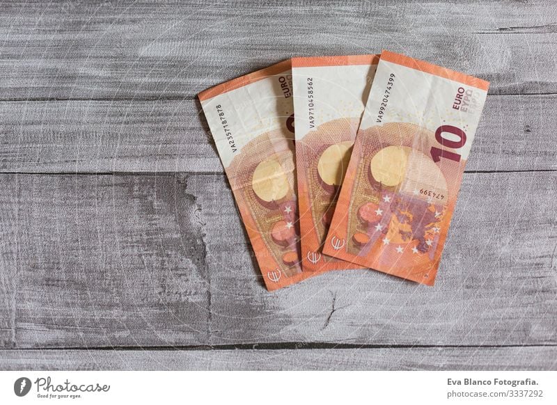Drei Zehn-Euro-Schein. Euro-Banknoten auf grauem Holzgrund. Das Geldkonzept Vermögen Stapel Hinweis Einkommen Löhne Gehalt zählen verkaufen Erträge Anhäufung