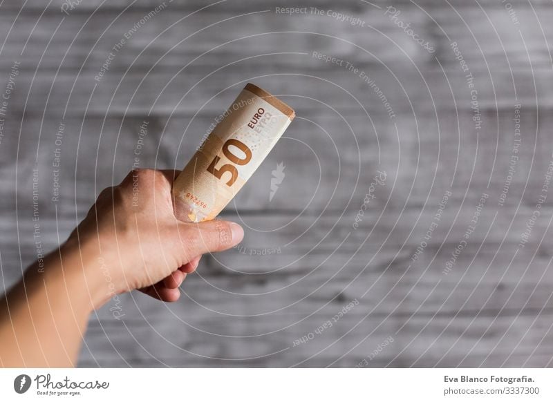 Frau hält isoliert auf grauem Holzuntergrund Bargeld in der Hand. Fünfzig Euro-Scheine. Europäer Geld Europa fünfzig Vermögen Halt Zahlung finanziell