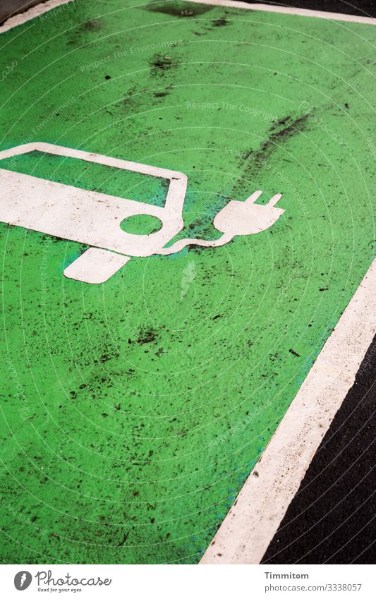 E-Auto tanken Umwelt Dorf Verkehr PKW Zeichen Linie warten grün schwarz weiß Gefühle Parkplatz E-Mobilität Ladestation dreckig Farbfoto Außenaufnahme