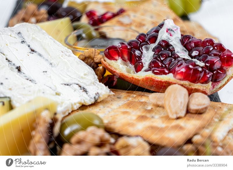 Speiseteller mit Trüffelkäse, Entenbrust, Briekäse, Pekannüssen, Granatapfelkernen, Trauben, Mandeln, Honig, Oliven und Crackern Weintrauben Saatgut Käse Platte