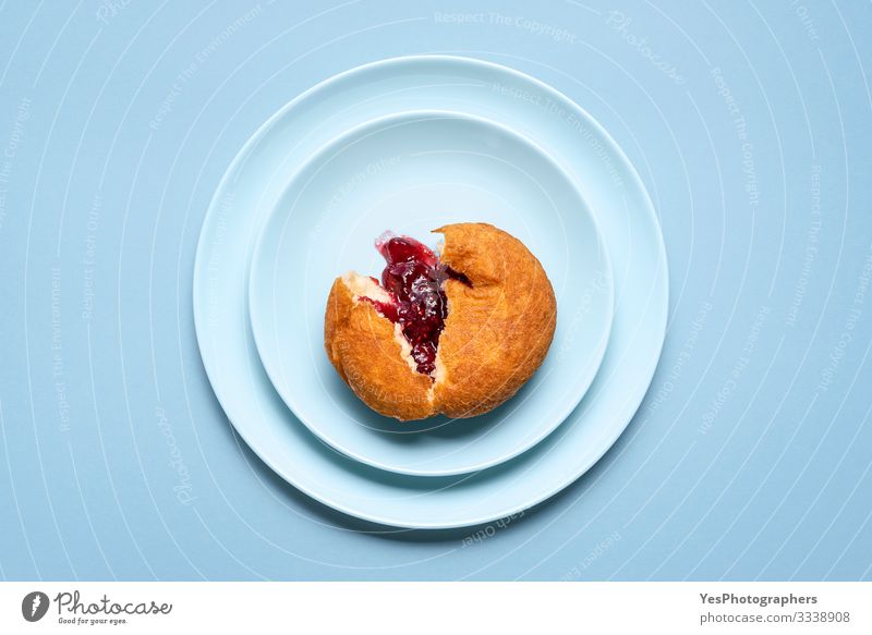 Ein Gelee-Donut auf einem Teller. Deutscher Krapfen mit Himbeermarmelade Kuchen Dessert Süßwaren Marmelade lecker Tradition Deutschland obere Ansicht Bäckerei