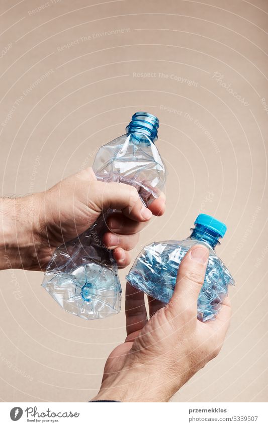 Männliche Hand hält gequetschte Plastikflasche Flasche sparen Mann Erwachsene Umwelt Container Kunststoff blau Umweltverschmutzung Müll wiederverwerten
