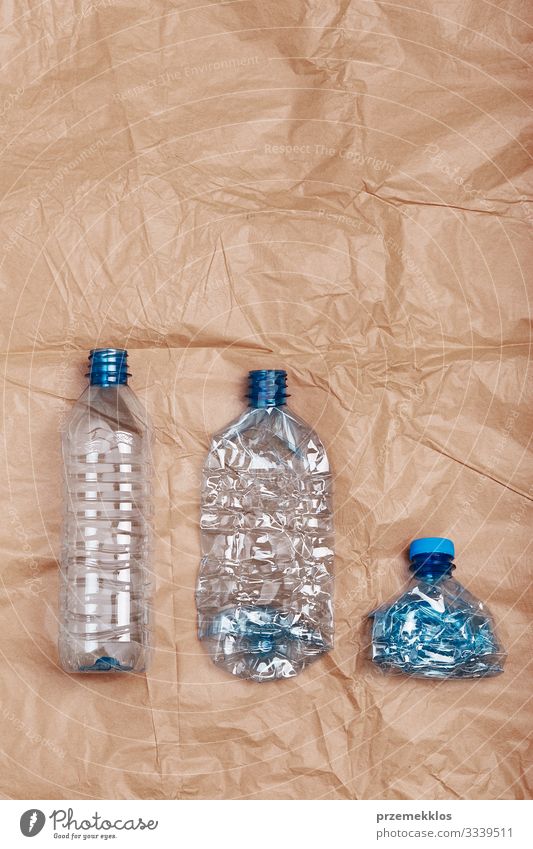 Zerquetschte leere Plastikflaschen in eine Reihe gestellt Flasche sparen Umwelt Container Papier Kunststoff blau braun Umweltverschmutzung Umweltschutz
