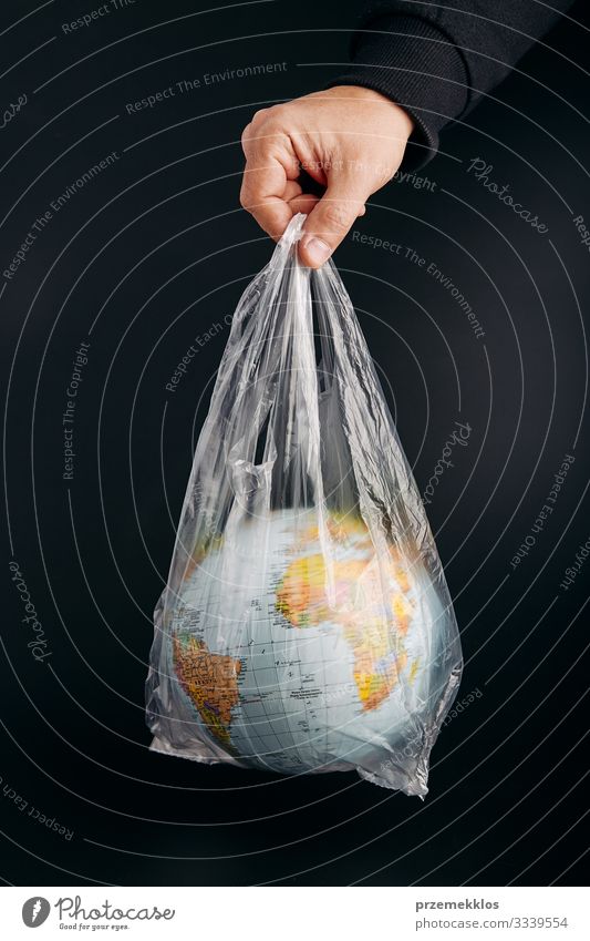 Männliche Hand hält den Globus in einer Plastiktüte. Kontaminierte Erde sparen Leben Mann Erwachsene Umwelt Kunststoff Kugel grün schwarz Umweltverschmutzung