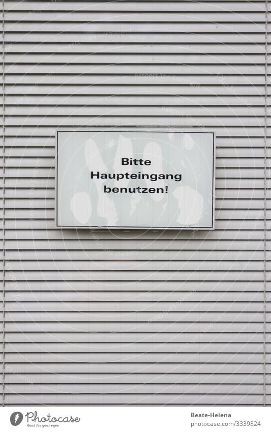 Druckerzeugnis l Schild "Bitte Haupteingang benutzen" vor quergestreifter Jalousie Hinweisschild Information Aufforderung Schilder & Markierungen Außenaufnahme