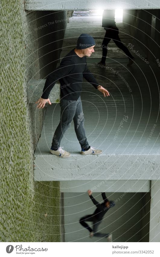 Mann steht an einer Mauer Mensch maskulin Erwachsene 1 45-60 Jahre Stadt Haus Fassade grau gehen Doppelgänger Le Parkour Illusion gedreht verdreht Klettern