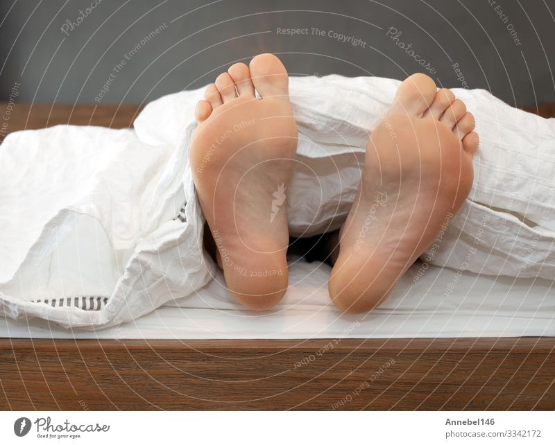 Ein Paar Füße allein im Bett auf weißen Blättern Haut Erholung Kind Schule Mensch Junge Mann Erwachsene Fuß schlafen bequem Farbe eine Decke Barfuß lügen