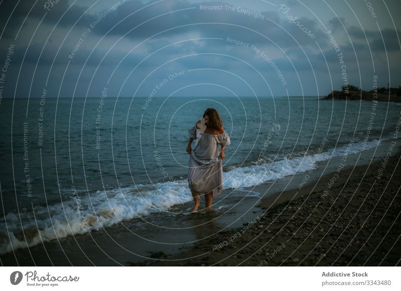 Weibliche Touristen am Meer Frau Strand Wellen Seeküste Barfuß Meeresufer Himmel Himmel (Jenseits) Abenddämmerung Wolken Dame laufen Küstenlinie leer einsam