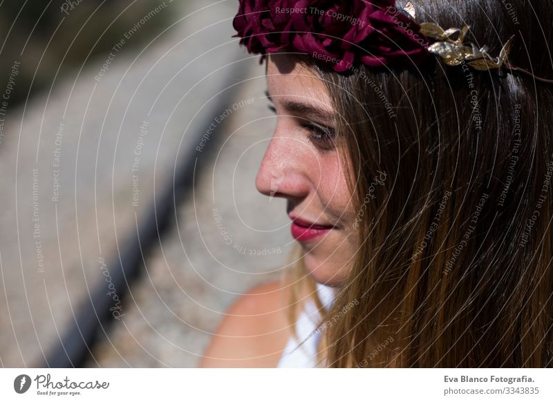 Profil Gesicht Portrait Schöne junge Frau mit einem roten Rosenkranz auf dem Kopf. Rote Lippen. Im Freien. Sonnig. Die Eisenbahn. Lebensstil Freiheit