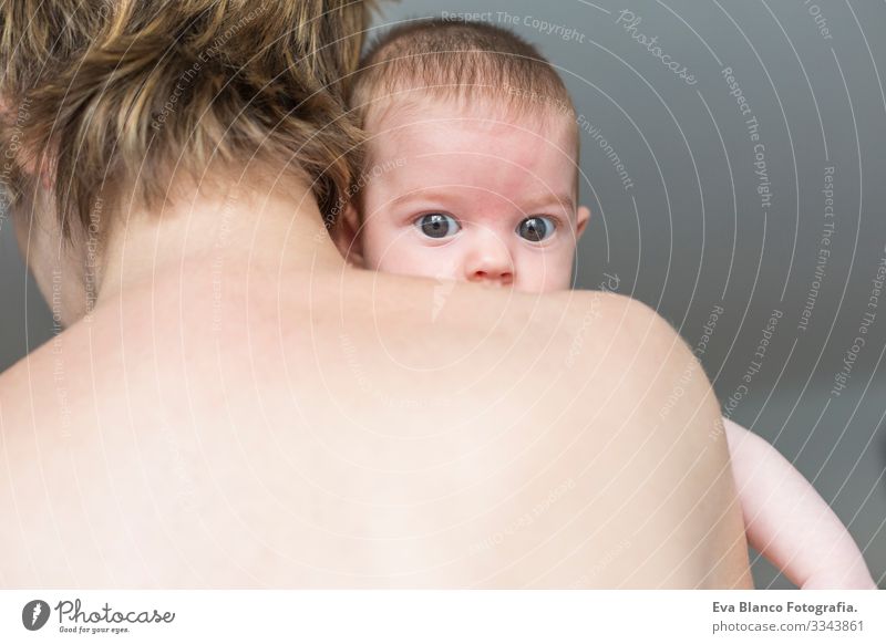 Rückansicht einer glücklichen Mutter mit ihrem entzückenden Kind, das ein Mädchen hält Baby niedlich klein Porträt Kindheit schön Gesicht unschuldig blaue Augen