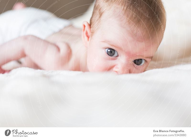 Porträt eines süßen Mädchens, das wach ist, sich hinlegt und in die Kamera schaut. Weiße Decke im Hintergrund Baby niedlich klein Kind Kindheit schön Gesicht