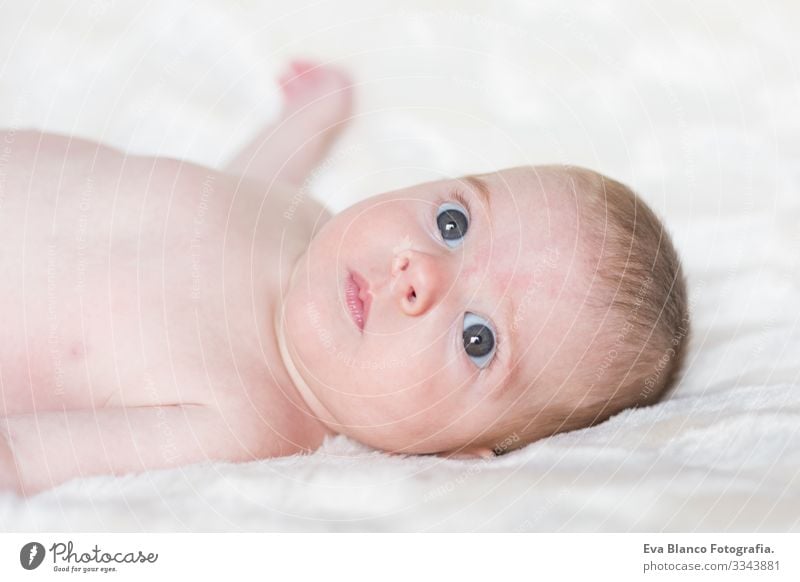 Porträt eines süßen Mädchens, das wach ist und in die Kamera schaut. Weiße Decke im Hintergrund Baby niedlich klein Kind Kindheit schön Gesicht unschuldig