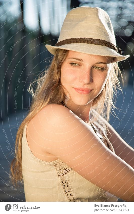 Porträt einer jungen Frau bei Sonnenuntergang Jugendliche Außenaufnahme Glück blond Hut blaue Augen Brücke Sommer Sonnenstrahlen Behaarung Fröhlichkeit